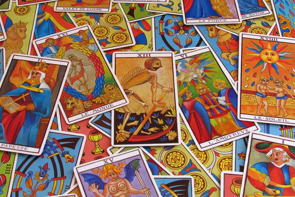 Marseille Tarot cards spread out: The Popess, The World, The Lover, The Sun and the unnamed card XIII