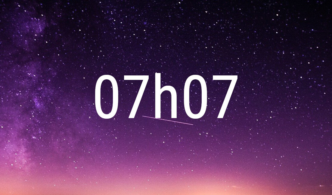 07:07 angel number in white digits on a starry purple night sky
