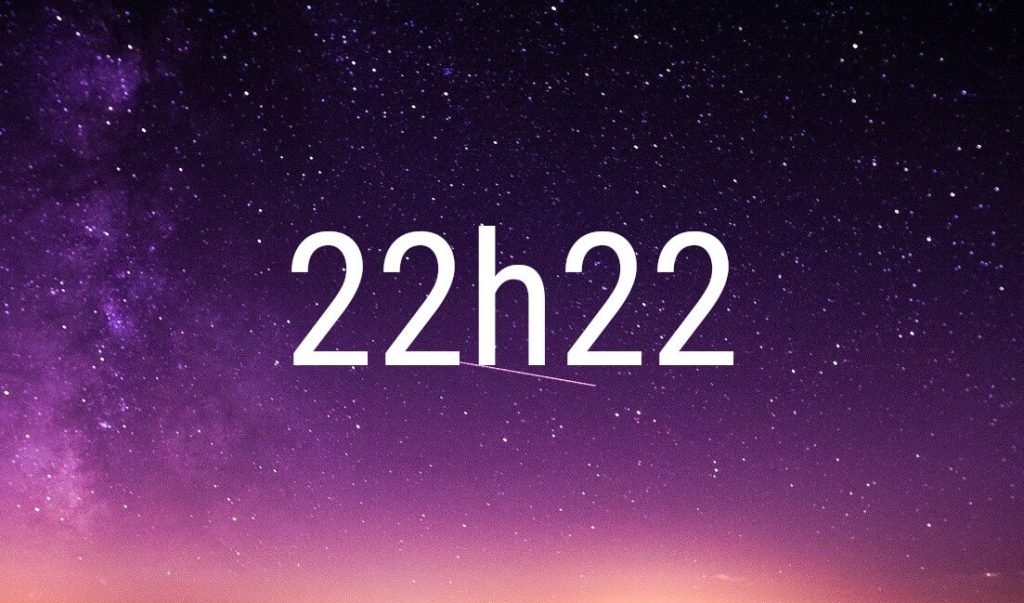 Hora espejo 22:22 en cifras blancas sobre un cielo estrellado violeta