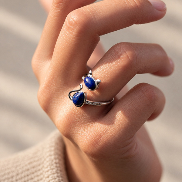 Bague chat en lapis lazuli portée, la main légèrement repliée.