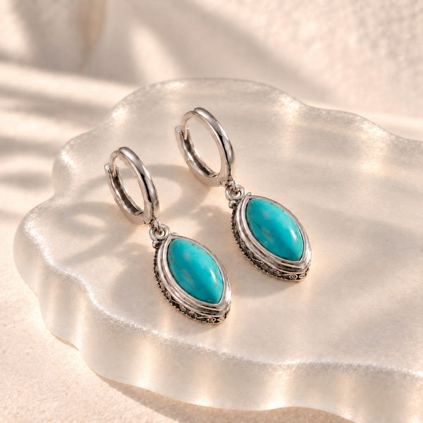 Lepida, boucles d’oreilles navette en turquoise posées, deux pierres bleu-vert sous de petites créoles argentées.