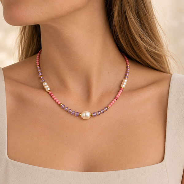 Collier en rhodonite, améthyste et perles d’eau douce porté sous la gorge, la grosse perle au milieu.
