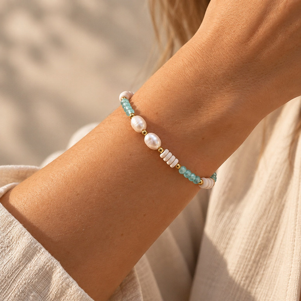 Bracelet en perles d’eau douce et perles bleues porté, gros plan sur le poignet.