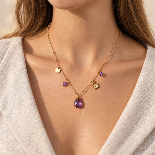 Collier à breloques en améthyste porté, la goutte au centre et les breloques de chaque côté de la chaîne.