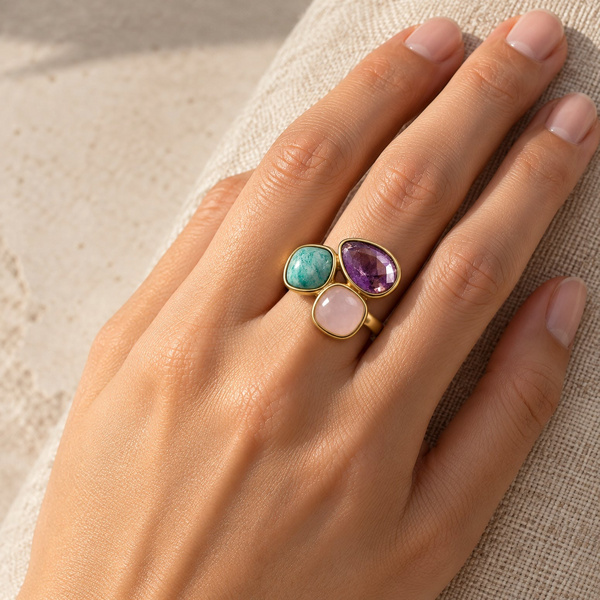 Bague en améthyste, quartz rose et amazonite portée, la main posée à plat.