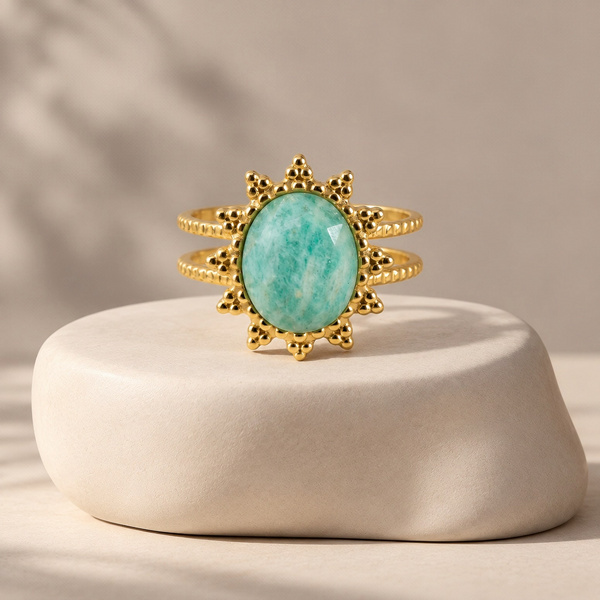 Gemma, bague fleur en amazonite vue de face, pierre ovale vert d’eau entourée de grappes de billes dorées.