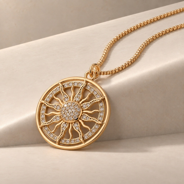 Aurea, collier soleil en zircon posé, médaille ronde ajourée aux rayons ondulés.