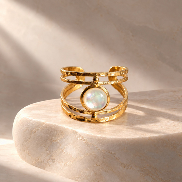 Myrrhine, bague martelée en nacre vue de face, rond irisé entre quatre joncs dorés battus.