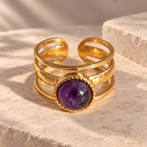 Bague trois anneaux en améthyste posée de face, pierre ronde violette dans un serti torsadé doré.