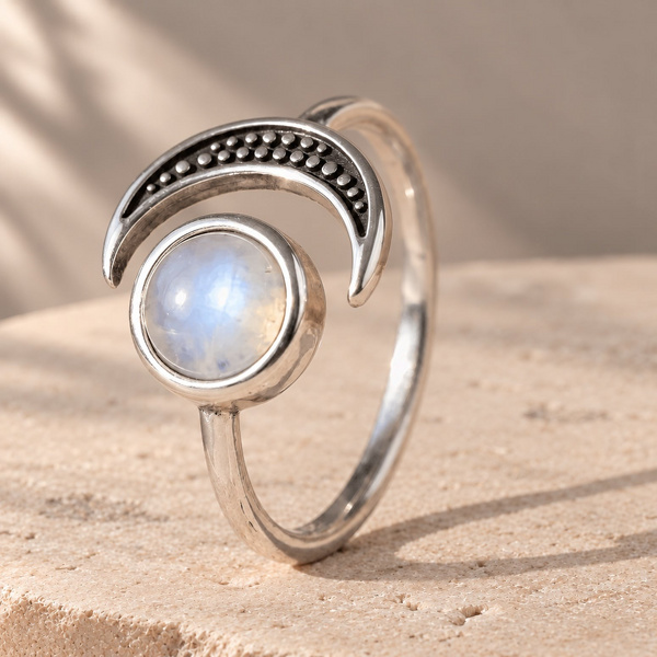Anyte, bague croissant en pierre de lune posée, cabochon blanc bleuté face à un croissant noirci et pointillé.
