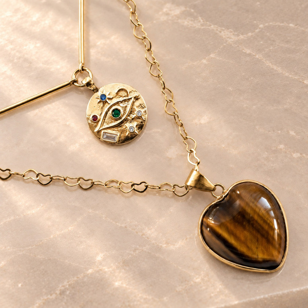 Collier double rang cœur en œil de tigre posé à plat, maillons en cœurs et disque semé de points colorés.