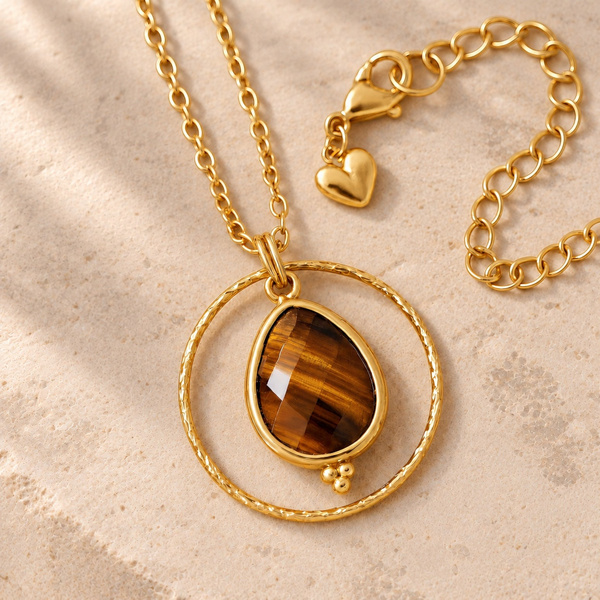 Xanthe, collier cercle en œil de tigre posé à plat, avec sa chaîne et son petit cœur doré.