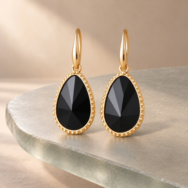 Glaphyra, boucles d’oreilles goutte en onyx noir posées, gouttes facettées dans un cadre doré perlé.