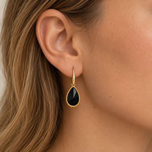 Boucles d’oreilles goutte en onyx noir portées, la goutte suspendue sous le lobe.
