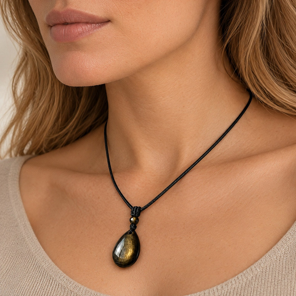 Pendentif mixte en obsidienne dorée porté de trois quarts, sur son cordon noir.