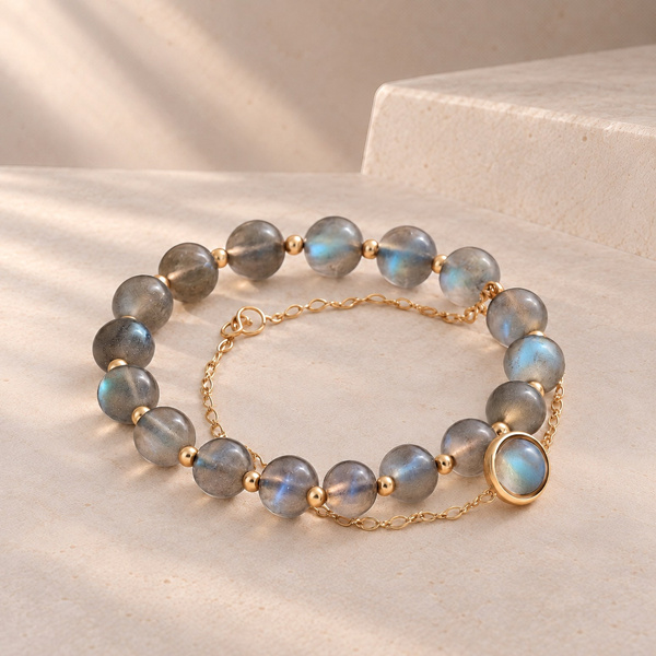 Duo de bracelets en labradorite posé, le rang de perles et la chaîne à cabochon entremêlés.